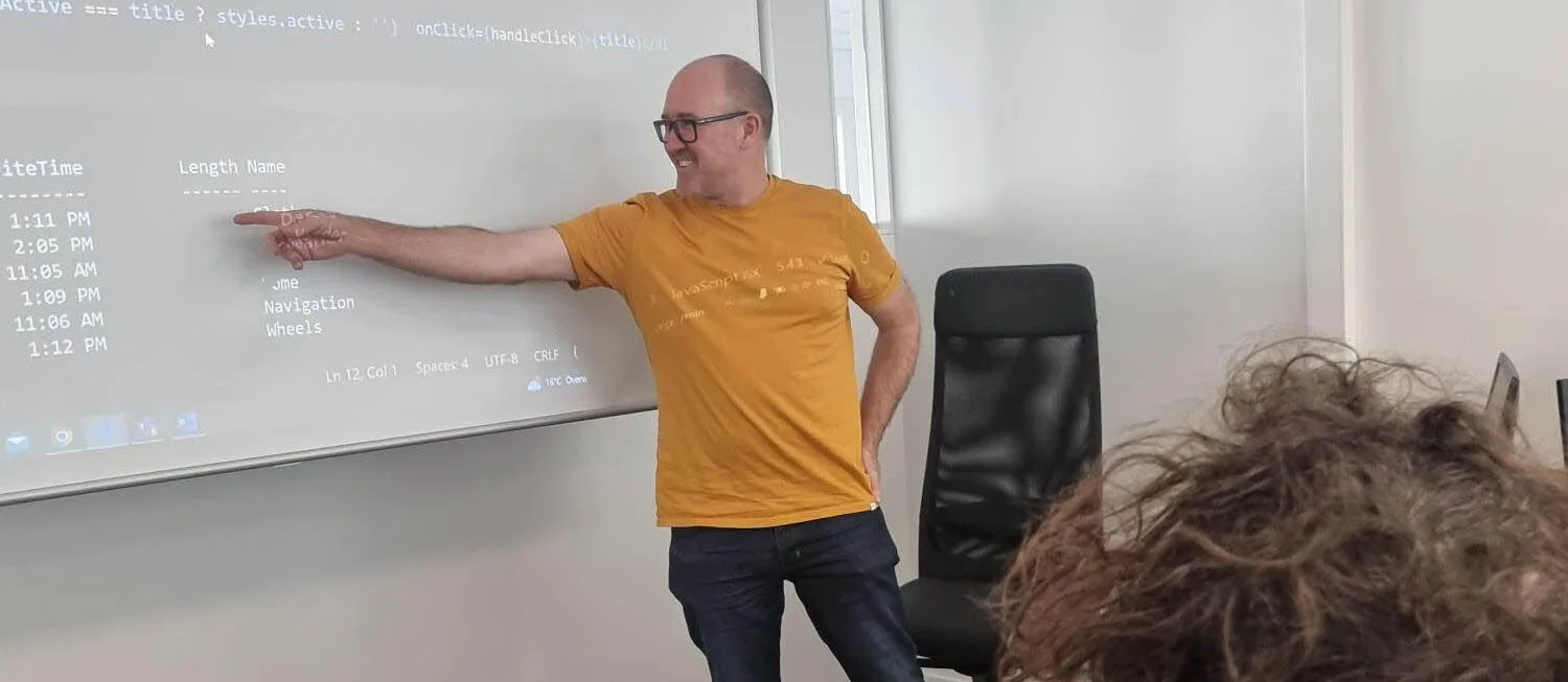 Head Teacher Robert Chamberlain teaching in front of an attentive Frontend Developer class.