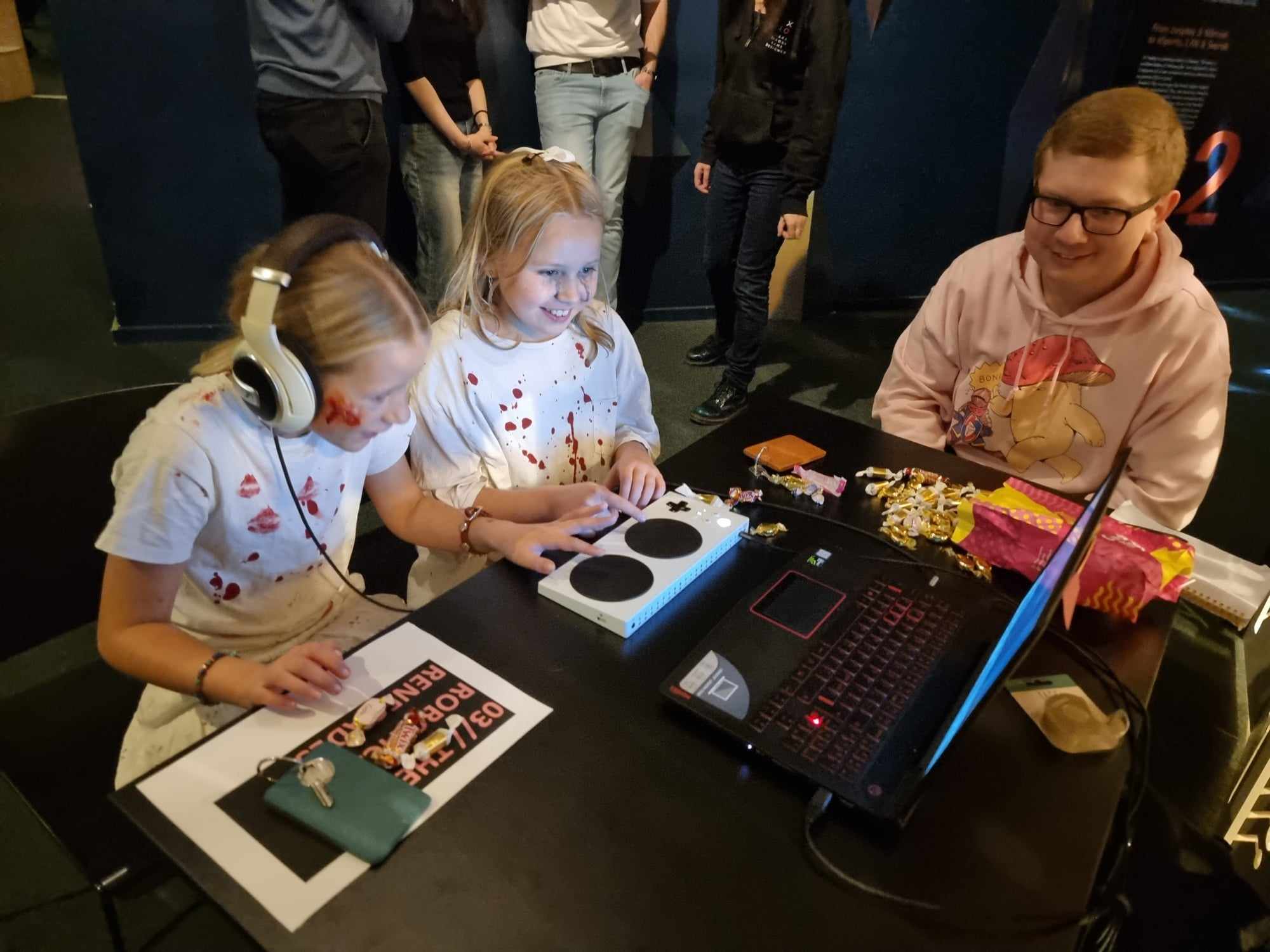 Children in Halloween costumes are playtesting video games alongside Futuregames students.