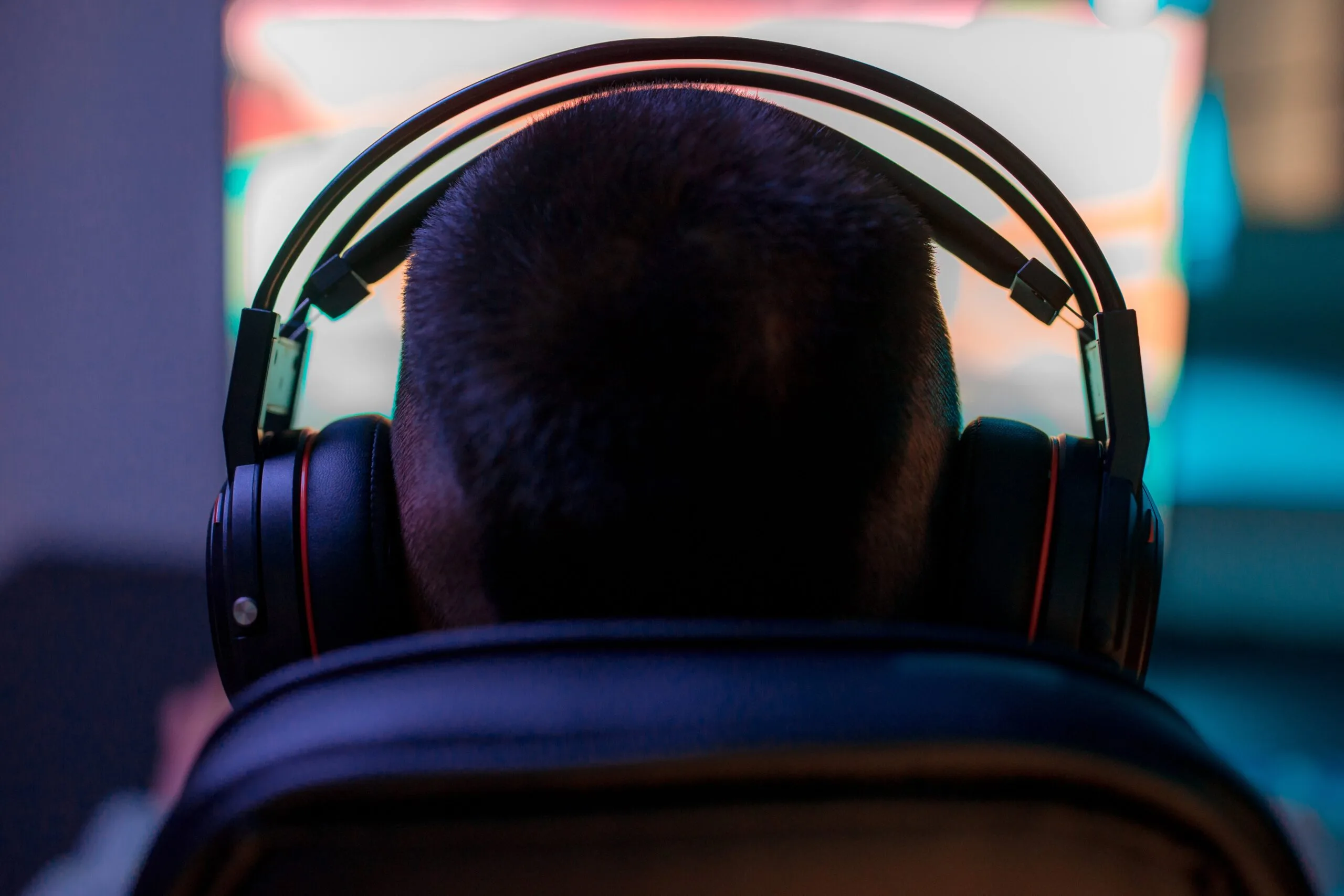 Gamer with headphones in front of computer.
