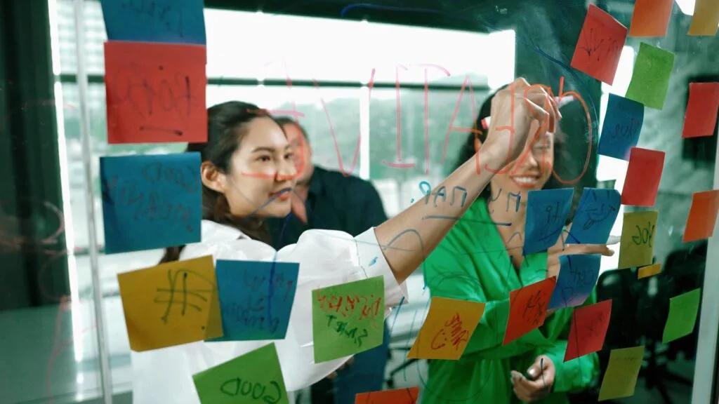 Students putting up post-its on a board.