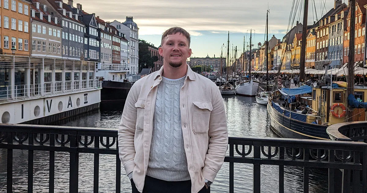 Futuregames alumnus Viktor Andersson standing on a bridge over a river running through a city