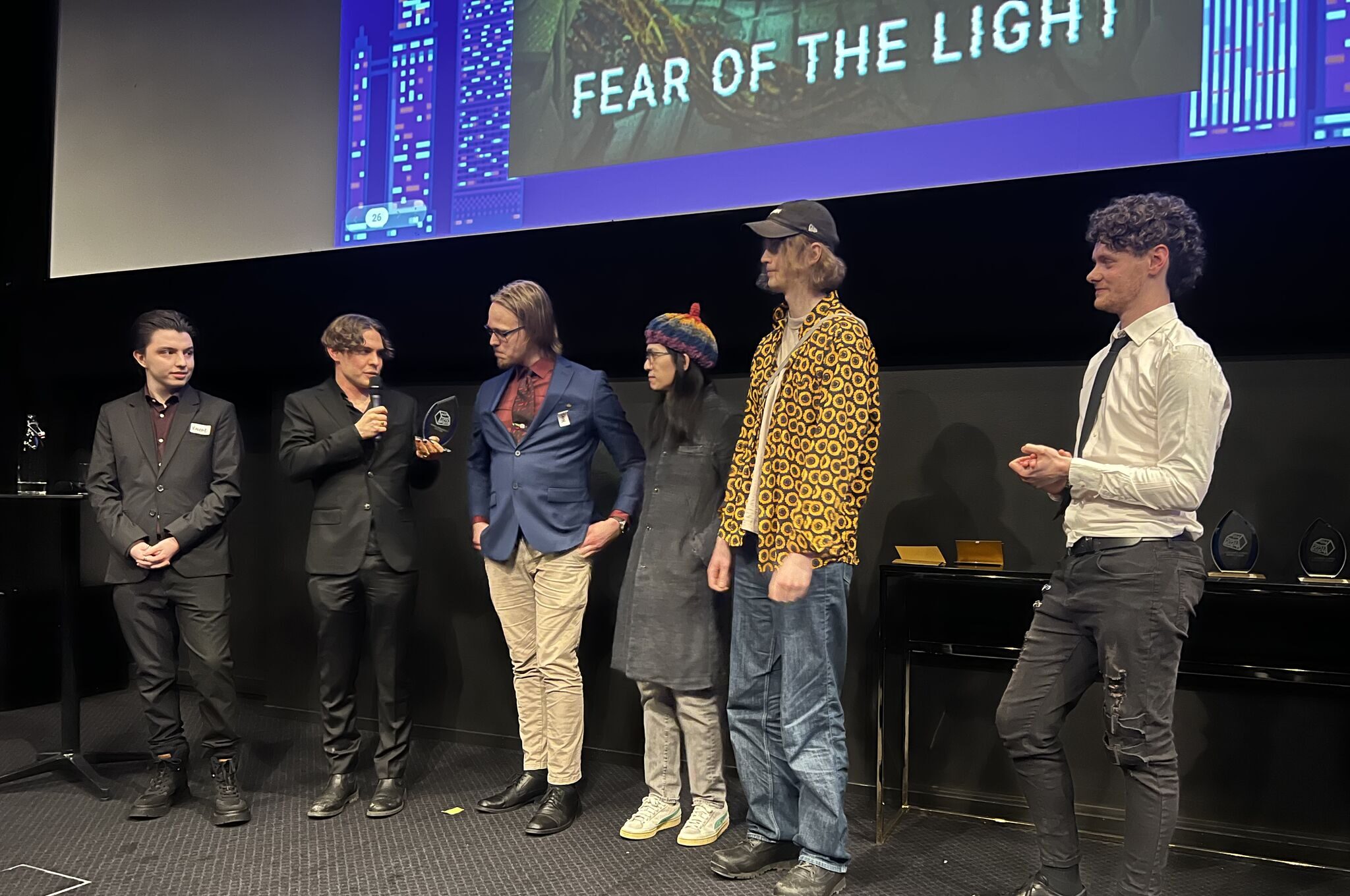 The team behind the award-winning game Fear of the Light receives their prize on stage.